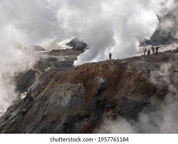 Climbing tourists to the Mutnovsky volcano. Tourists admire the view of the snow-capped mountains of the volcano and the steam coming out of the fumaroles. Kamchatka Peninsula, Russia. - Powered by Shutterstock