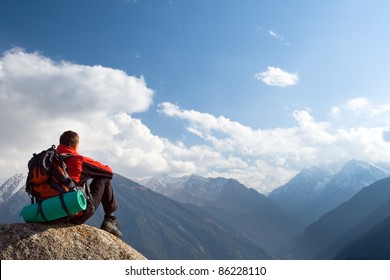 Climbing young adult at the top of summit with aerial view of the blue sky - Powered by Shutterstock