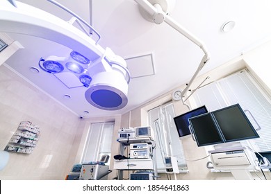 Clinic interior with operating surgery table, lamps and ultra modern devices, technology, hi-tech interior. - Shutterstock ID 1854641863