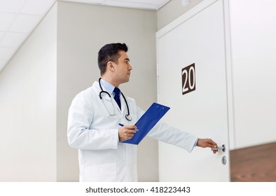 Clinic, People, Health Care And Medicine Concept - Doctor With Clipboard Opening Hospital Ward Door