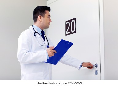 Clinic, People, Health Care And Medicine Concept - Doctor With Clipboard Opening Hospital Ward Door