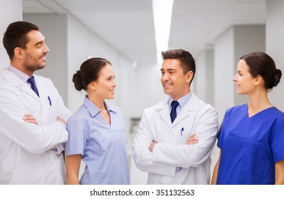 Clinic, Profession, People, Health Care And Medicine Concept - Happy Group Of Medics Or Doctors At Hospital Corridor