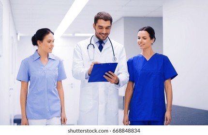 clinic, profession, people, health care and medicine concept - group of smiling medics or doctors with clipboard walking along hospital corridor - Shutterstock ID 668848834