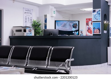 Clinic Registration Counter In Waiting Room Lobby, Computer To Make Checkup Appointments With Healthcare Report Papers. Empty Hospital Reception Desk With Medical Forms And Insurance Support.