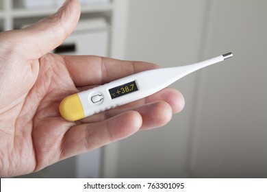 clinical thermometer in the left hand of a physician showing high fever