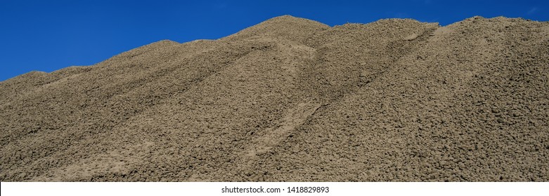 Clinker Surface In A Raw Material Warehouse And Blue Sky, Cement Production. Web Banner For Your Design.