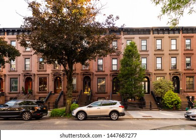 Clinton Hill, Brooklyn, United States - June 30, 2019: Scenic view of a classic Brooklyn brownstone block with a long facade and ornate stoop balustrades on a summer day in Clinton Hills, Brooklyn