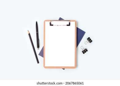 Clipboard with blank paper sheet mockup and stationery on a blue background. Workspace for education.