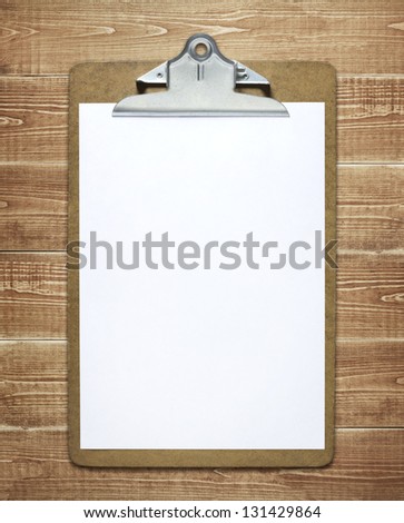 Clipboard with a blank sheet of paper on wooden table