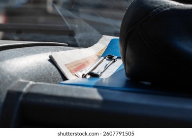A clipboard can be found resting on the dashboard of a car, providing easy access to important documents or notes while driving
