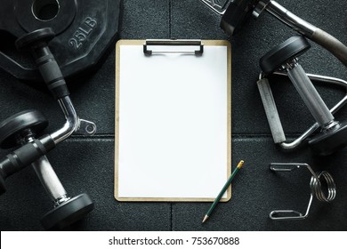 Clipboard For Check List With Free Copy Space In Gym With Fitness Equipment Background