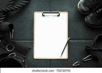 Clipboard Check List In Gym With Fitness Sport Equipment Background