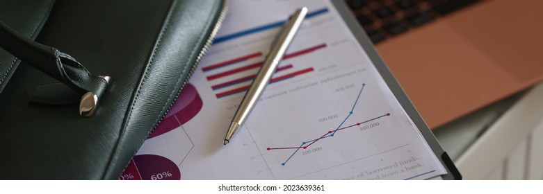 Clipboard Documents And Ballpoint Pen Lying On Open Green Laptop Bag Closeup