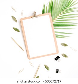 clipboard with empty copy space blank, golden pen and clips, petals and palm branch on white background. flat lay, top view
