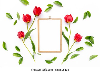 Clipboard mock up with beautiful red tulips isolated on white background. Flat lay, top view. Minimalistic office desk. Beauty blog concept.