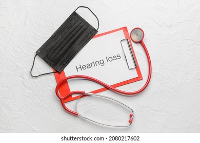 Clipboard With Text HEARING LOSS, Stethoscope And Medical Mask On White Background