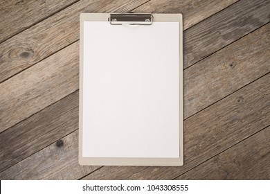 Clipboard With White Sheet On Wooden Background