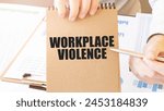 Clipboard with WORKPLACE VIOLENCE text being held by a person over financial charts.