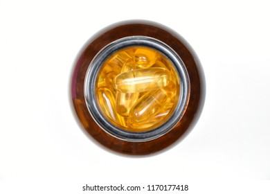 Clipping Path. Flat Lay(Top View) Of Fish Oil Capsules Yellow(gold) Gel In Brown Pill A Bottle With Isolated On White Background View. Macro.