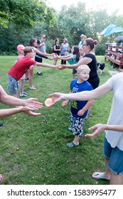 CLITHERALL, MINNESOTA / USA - JULY 14, 2017: Extended Family Of Three Generations Starting A Water Balloon Toss Game. 