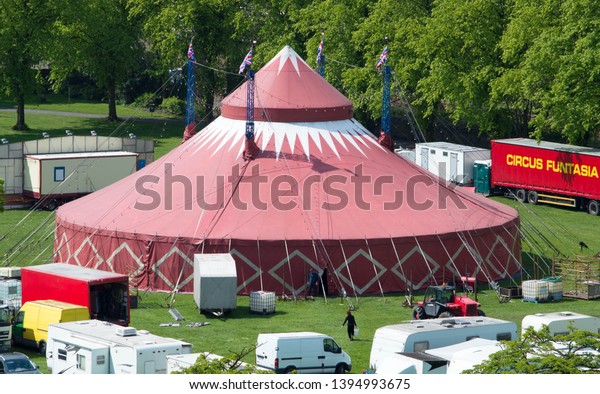 Clitheroe, Lancashire/UK - May 11th 2019:\
Funtasia circus with big top tent being set up in large field with\
trucks, vans and\
workers