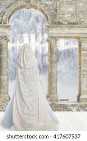 cloaked woman by castle lake
