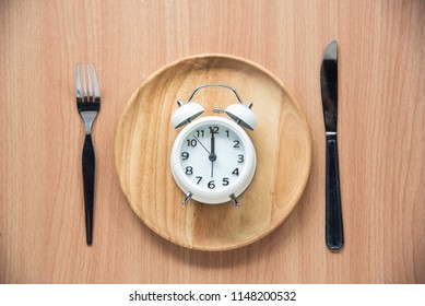 The Clock Is At 12:00 Noon For Lunch In A Wooden Dish.