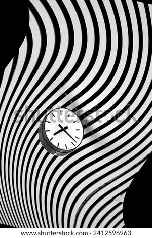 Clock in black and white on bent striped pattern