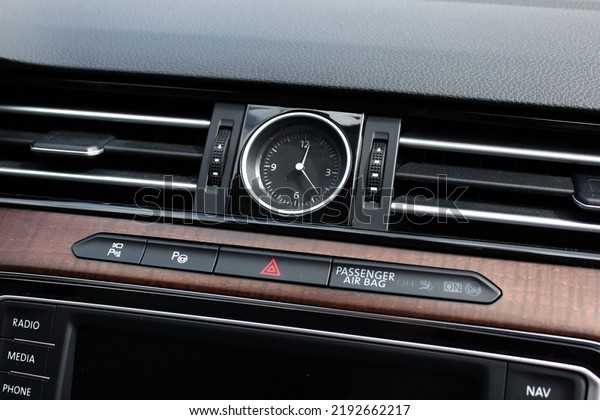 Clock in the center interior car. Modern luxury\
car with natural wood panel. Detailing. Interior of prestige car.\
Warning light switch in a\
car.
