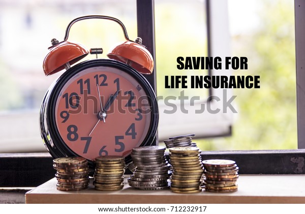 Clock and coin with the word SAVING FOR LIFE\
INSURANCE - the concept of\
savings
