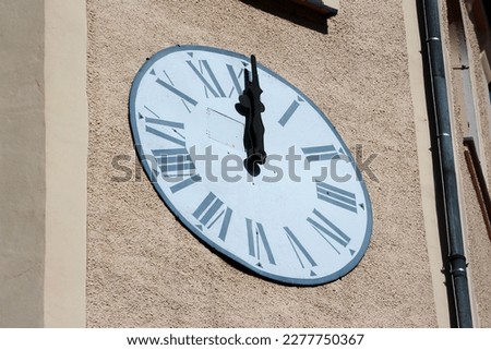 Clock dial on a bell tower at noon