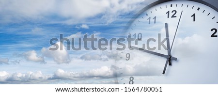 Clock face in blue sky. Time passing