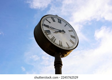 The clock face on the background of the blue sky at sunset