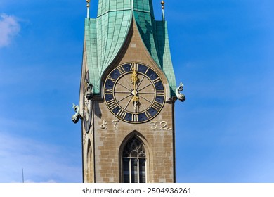 Clock face of Women's Minster at Swiss City of Zürich showing exact twelve o'clock time on a sunny summer noon. Photo taken August 19th, 2024, Zurich, Switzerland. - Powered by Shutterstock