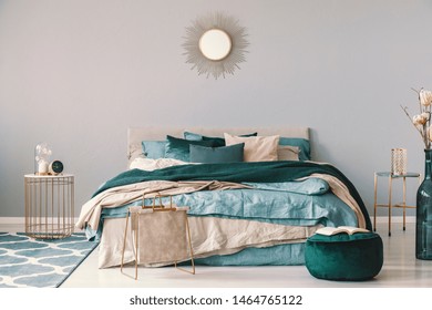 Clock And Flower In Fancy Vase On Nightstand Table Next To King Size Bedroom With Emerald Green And Beige Bedding