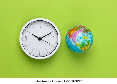 Clock and globe on a green background. World time. Top view