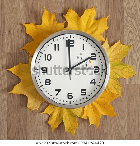A clock, the gray hand points to three o'clock, the black one to two o'clock. The orange arrow indicates the direction of movement of the hands. Time change symbol. Standard time in winter.