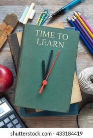 Clock hands pointing towards time to learn on book with educational items around it