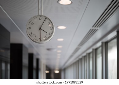Clock hanging from the ceiling in an office