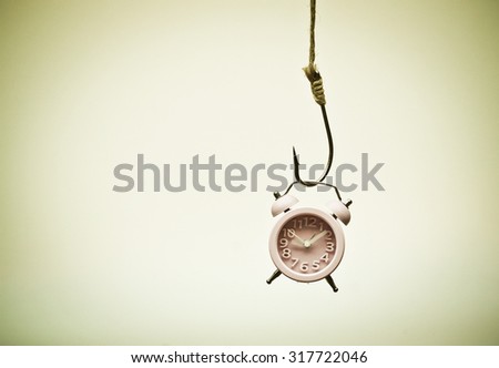 A clock hung on a fish hook - Time trap concept