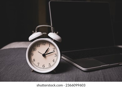 The clock and laptop for work life balance concept and time manage meant . dark mode