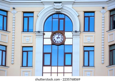 clock on the facade of a building with windows