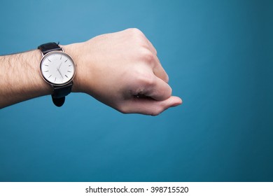 The clock on the man's hand on a blue background - Shutterstock ID 398715520