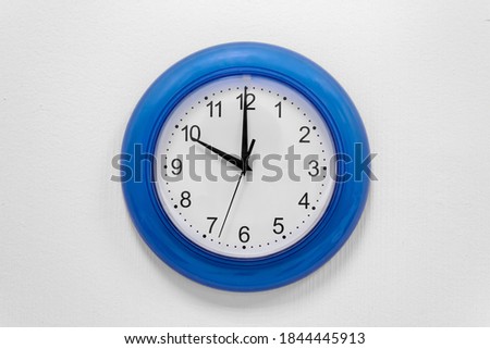 the clock on the wall shows ten o'clock. clock with a blue frame. ten o'clock in the morning, evening. 