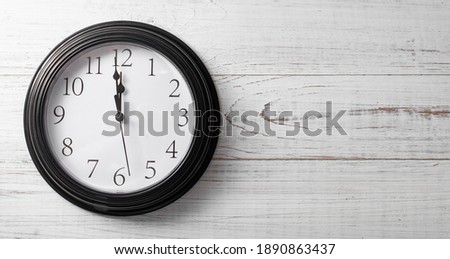 Clock on a white background. A minute to twelve. Banner. Place for your text.
