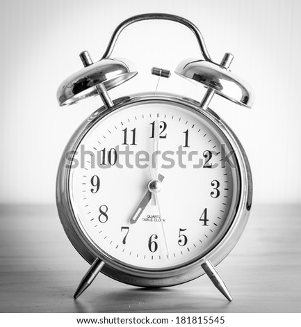 Retro alarm clock with bells over red paper background
