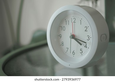 Clock showing time on a table near a window