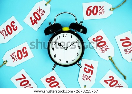 Clock surrounded by various discount tags with percentages like 10%, 20%, 30%, up to 90% off, set against a bright blue background
