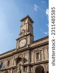 The clock tower of 16th-century Giureconsulti Palace, in piazza Mercanti (Merchants Square), with St Ambrose statue, Milan city center, Italy