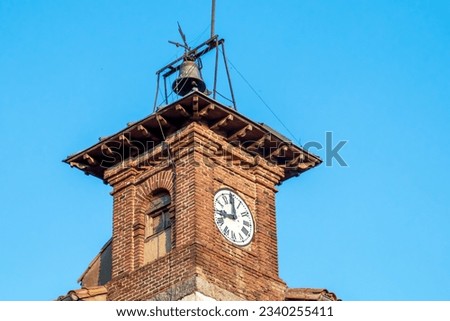 Clock tower of the school in the town of Hoyos del Espino, Ávila, Spain. Clock built in the traditional architecture of the time on the roof of the school in the 20s.